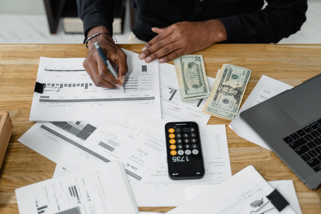 a person counts expenses. next to the calculator and money
